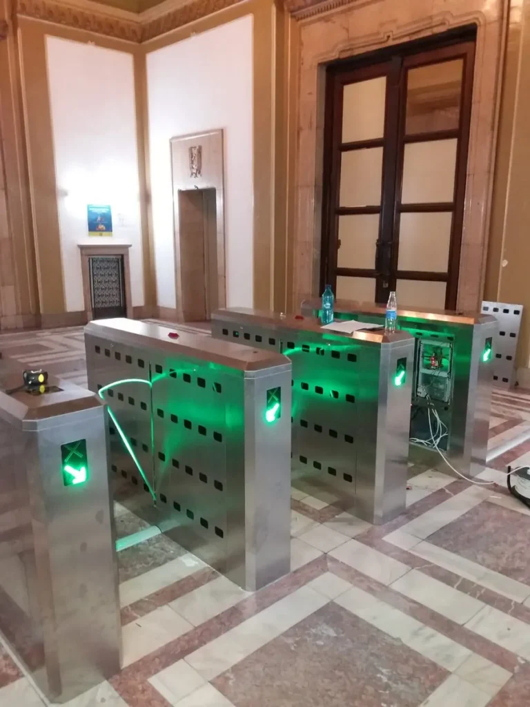 Porți de acces cu indicatoare luminoase, montate în fața unei uși istorice de lemn