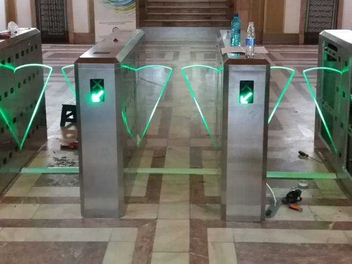 Porți de acces cu panouri de sticlă în holul unei clădiri publice